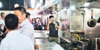 7月17日，渝州路某餐饮企业，环保工作人员和部分餐饮企业代表在查看厨房的排烟系统。首席记者 崔力 摄 - 重庆新闻网