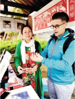 　　传承人杨玲(左)给外国友人展示剪纸工艺。 - 重庆新闻网