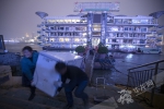 12月27日，“鑫缘渔港”停业后，搬运工人将船上的物品抬上码头。华龙网-新重庆客户端记者 张质 摄 - 重庆晨网