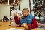 11月29日，在迪马凯尔慈喜渝北龙塔养老服务中心，工作人员正在为老人整理衣物.jpg - 重庆晨网