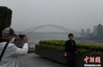 图为重庆主城遭遇大雾天气，市民在岸边围栏处拍照玩耍。　周毅 摄 - 重庆晨网