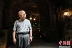 图为8月11日，粟远奎在重庆大轰炸“六·五”隧道惨案遗址防空隧道内。 中新社记者 何蓬磊 摄 - 重庆晨网