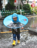 小孩子跑过积水路段。华龙网-新重庆客户端首席记者 李文科 摄 - 妇联