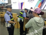 2一名民警与消费者沟通，另一名民警向手机店工作人员小霍了解情况。记者 张勇 摄.jpg - 重庆晨网