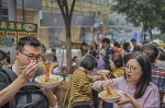 10月5日，渝中区民权路，来自江苏的游客正在品尝正宗重庆小面，麻和辣让第一次尝试的他们欲罢不能。记者 万难 摄 - 重庆新闻网